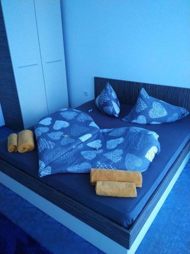 a blue bed with blue sheets and pillows at Pomorie Direkt am Pool in Pomorie