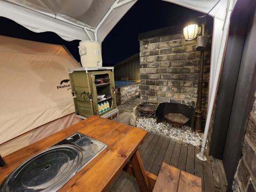 a tent with a wooden table and a wood stove at Hotel 498 in Incheon