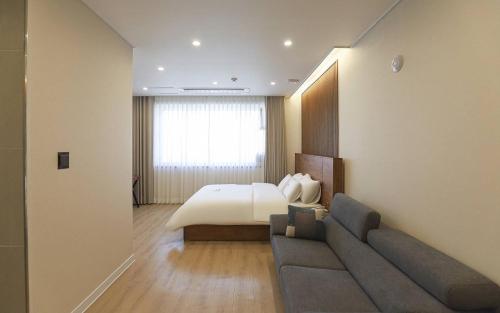 a hotel room with a bed and a couch at Hotel Grand Bay Boryeong in Boryeong