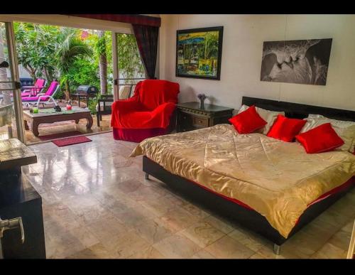 1 dormitorio con 1 cama y 1 silla roja en Siri Villa en Jomtien Beach