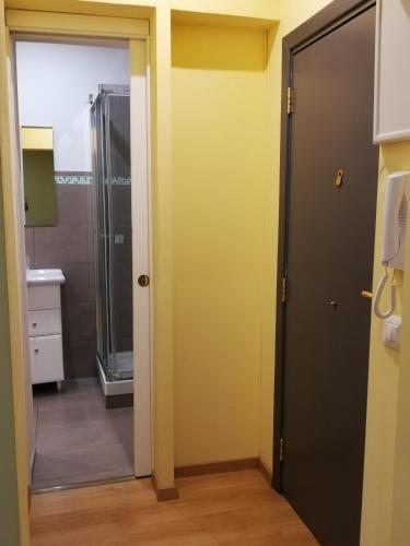 a bathroom with a shower and a glass door at Candelieri Suites in Sassari