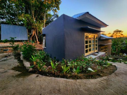 a small house with a garden in front of it at D'flora Bungalow & Glamping in Noca