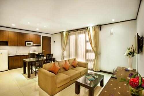 een woonkamer met een bank en een keuken bij Summer Hills Hotel & Villas Bandung in Bandung