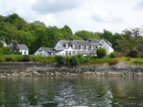 
a house on a hillside next to a body of water at The Creggans Inn in Strachur
