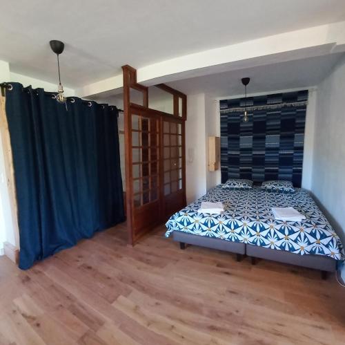 1 dormitorio con 1 cama en una habitación con suelo de madera en La pinède, 50 m2, 3 mn à pied des plages, lit King Size, en La Seyne-sur-Mer