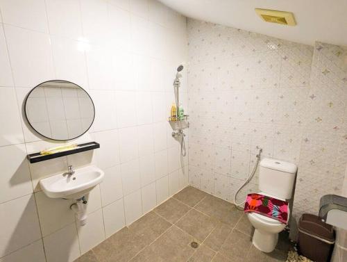 a bathroom with a sink and a toilet and a mirror at Lovina A5 no 3 at Baloi Impian - Grand Batam Mall in Nagoya