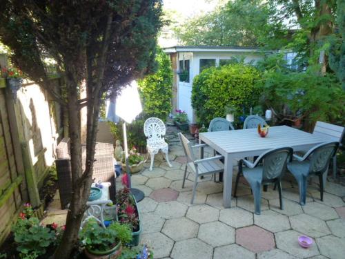 a patio with a table and chairs in a yard at House o' Books in London