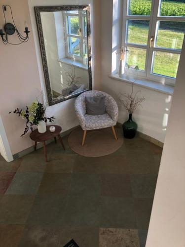 a living room with a chair and a mirror at Gästehaus Annemaria in Retz