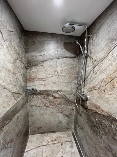 a shower in a bathroom with a stone wall at Chambre de charme n2 in Grimaud