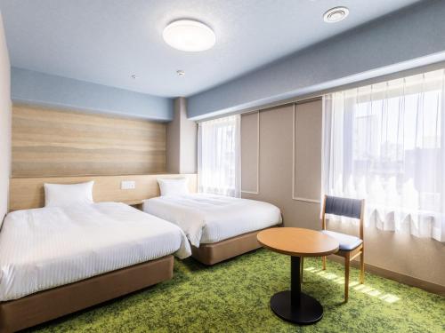 A bed or beds in a room at Hotel Wing International Shizuoka