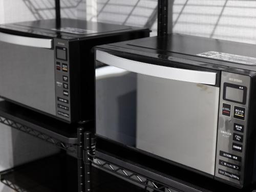 two microwaves sitting on a shelf in a kitchen at Hotel Wing International Shizuoka in Shizuoka