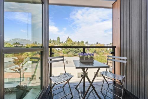 einen Tisch und zwei Stühle auf einem Balkon mit Aussicht in der Unterkunft University of Washington New Apartment Studio w/kitchen and balcony in Seattle