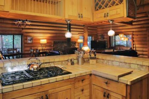 a kitchen with a stove and a counter top at Eagles Nest - Natural Log Cabin with Guest House in Idyllwild