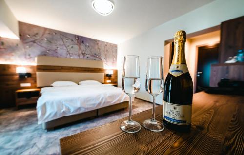 a bottle of champagne and two glasses on a table in a hotel room at La MOONte in Păltiniş