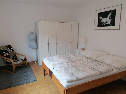 ein Schlafzimmer mit einem Bett und einem Stuhl darin in der Unterkunft Wundervolle Familienwohnung nahe Schönbrunn in Wien