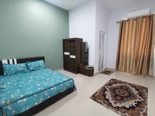 una camera con letto, armadio e tappeto di Sunshine Homestay a Kuala Terengganu