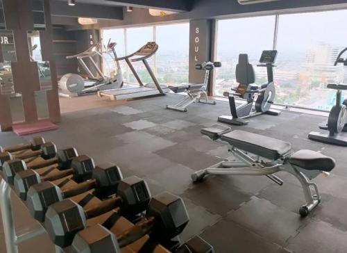 a gym with chairs and exercise equipment in a building at Channel Stay Warhol Simpang Lima Semarang in Semarang