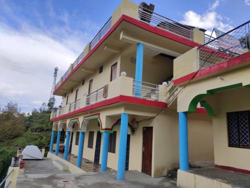 a building with blue columns at Prince Homestay & Restaurant in Rudraprayāg
