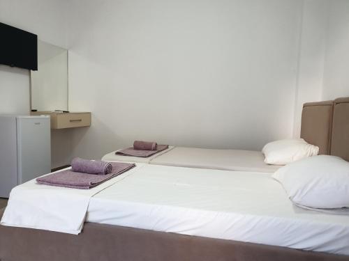 twee bedden naast elkaar in een kamer bij Rooms by George in Dhërmi