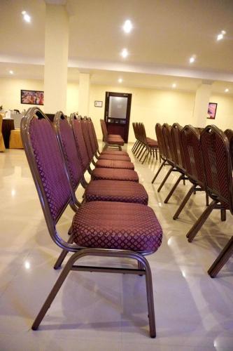 a row of chairs with purple seats in a room at HOTEL MEENAKSHI in Kolattupuzha