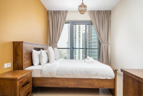 a bedroom with a bed and a large window at ALH Vacay - 2 bedrooms Apartment in Golf Towers 1 in Dubai