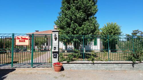une clôture verte avec un panneau devant une maison dans l'établissement La Contea, à Acqui Terme