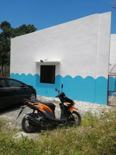 uma moto estacionada em frente a um edifício em Bluewaves Apartment em Dauis