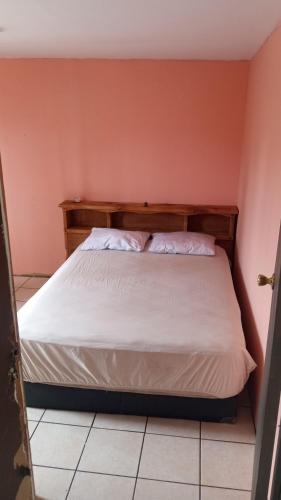 um quarto com uma cama com lençóis brancos em Casa shoke em Rosarito