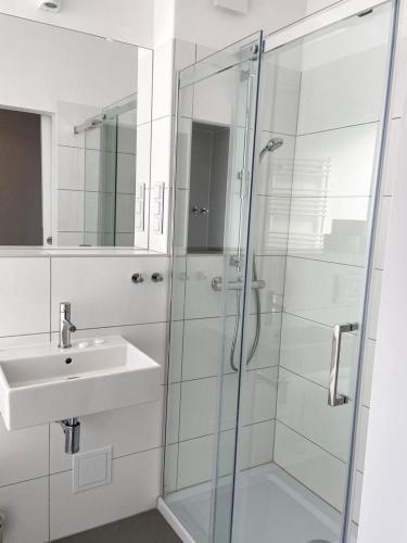 a bathroom with a glass shower and a sink at Ośrodek Magnolia in Ustroń