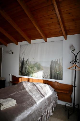 a bedroom with a bed with a painting on the wall at Lakeside Terrace in Neot Golan