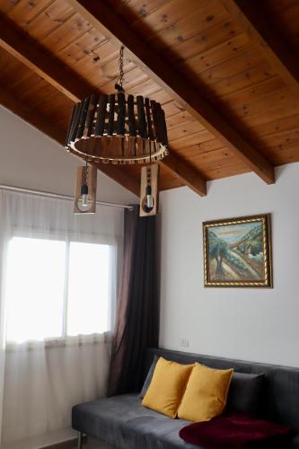 a chandelier in a living room with a couch and a window at Lakeside Terrace in Neot Golan