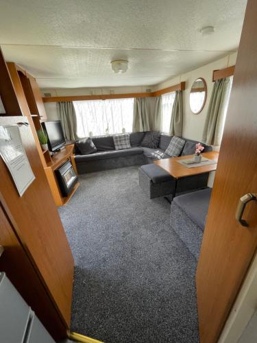 an rv living room with a couch and a table at Tessas caravan breaks in Chapel Saint Leonards