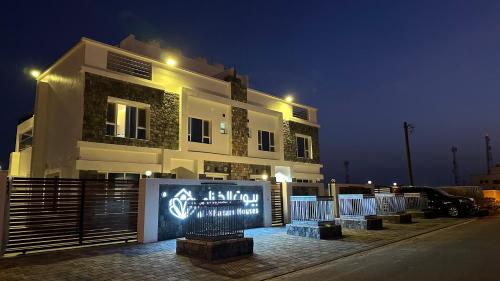 a building with a sign in front of it at night at بيوت الخزام in Salmah