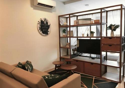 a living room with a couch and a flat screen tv at Timurbay Seafront Residence & Suites in Kuantan