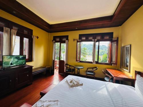 Кровать или кровати в номере Villa Phonethip Mekong Riverside