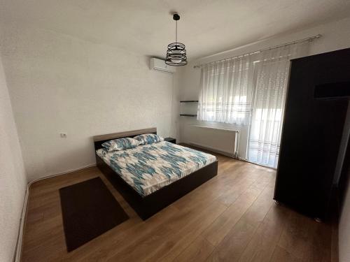 - une chambre avec un lit et une grande fenêtre dans l'établissement Central Apartment, à Strumica