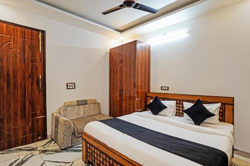 een slaapkamer met een bed en een stoel erin bij HOTEL PLATINUM Noida 144 in Noida