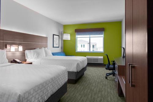 LeanderにあるHoliday Inn Express & Suites Leander, an IHG Hotelのベッド2台と窓が備わるホテルルームです。