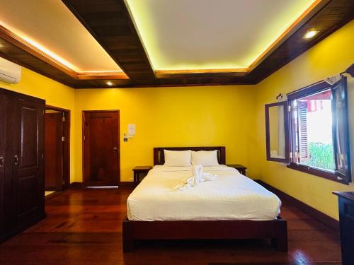 Кровать или кровати в номере Villa Phonethip Mekong Riverside