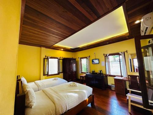 Кровать или кровати в номере Villa Phonethip Mekong Riverside
