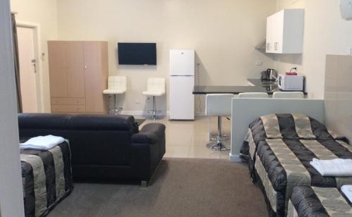 a living room with a couch and a kitchen at Avalon Motel in Mount Gambier