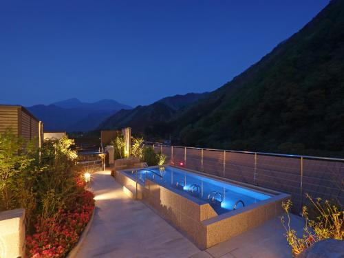 a swimming pool on top of a house with mountains at Asaya in Nikko