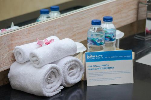 a pile of towels and bottles of water on a counter at Villa Bon Bon in Canggu