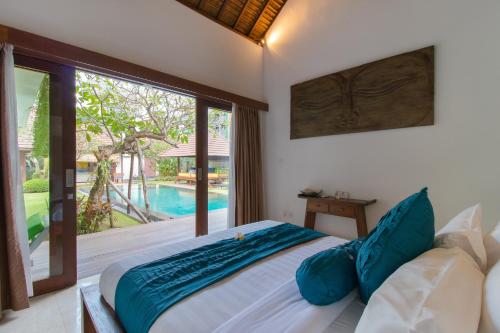 a bedroom with a bed and a view of a pool at Villa Bon Bon in Canggu