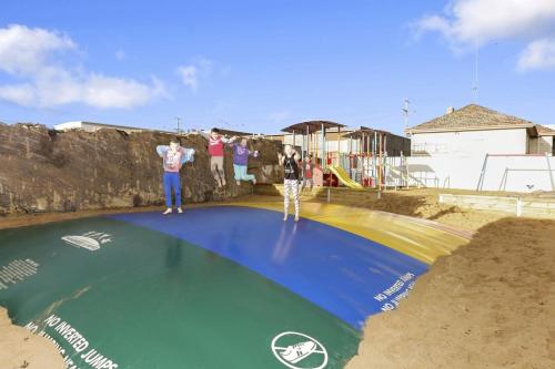 a man standing on top of a water slide at Warrnambool Holiday Village in Warrnambool