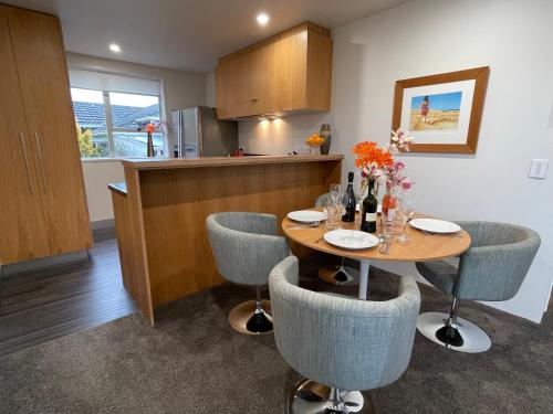 a kitchen with a table with chairs and a counter at Plymouth Central City 2 Bedroom Apartments in New Plymouth