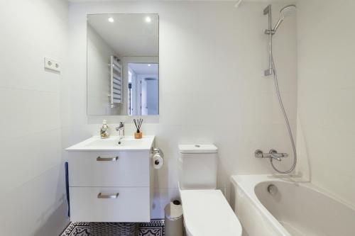 a white bathroom with a sink and a toilet at Sunsets and the pool in Barcelona in Cornellà de Llobregat