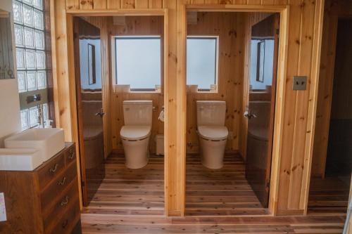 a bathroom with two toilets and two sinks at ゲストハウス麓〼-Rokumasu in Yokooka