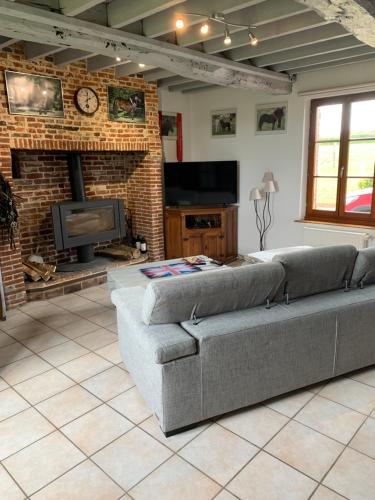 a living room with a couch and a tv at chambre d'hôtes in Beaubec-la-Rosière