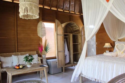 sypialnia z łóżkiem i stołem w obiekcie Green Village Jungle Resort w mieście Nusa Penida